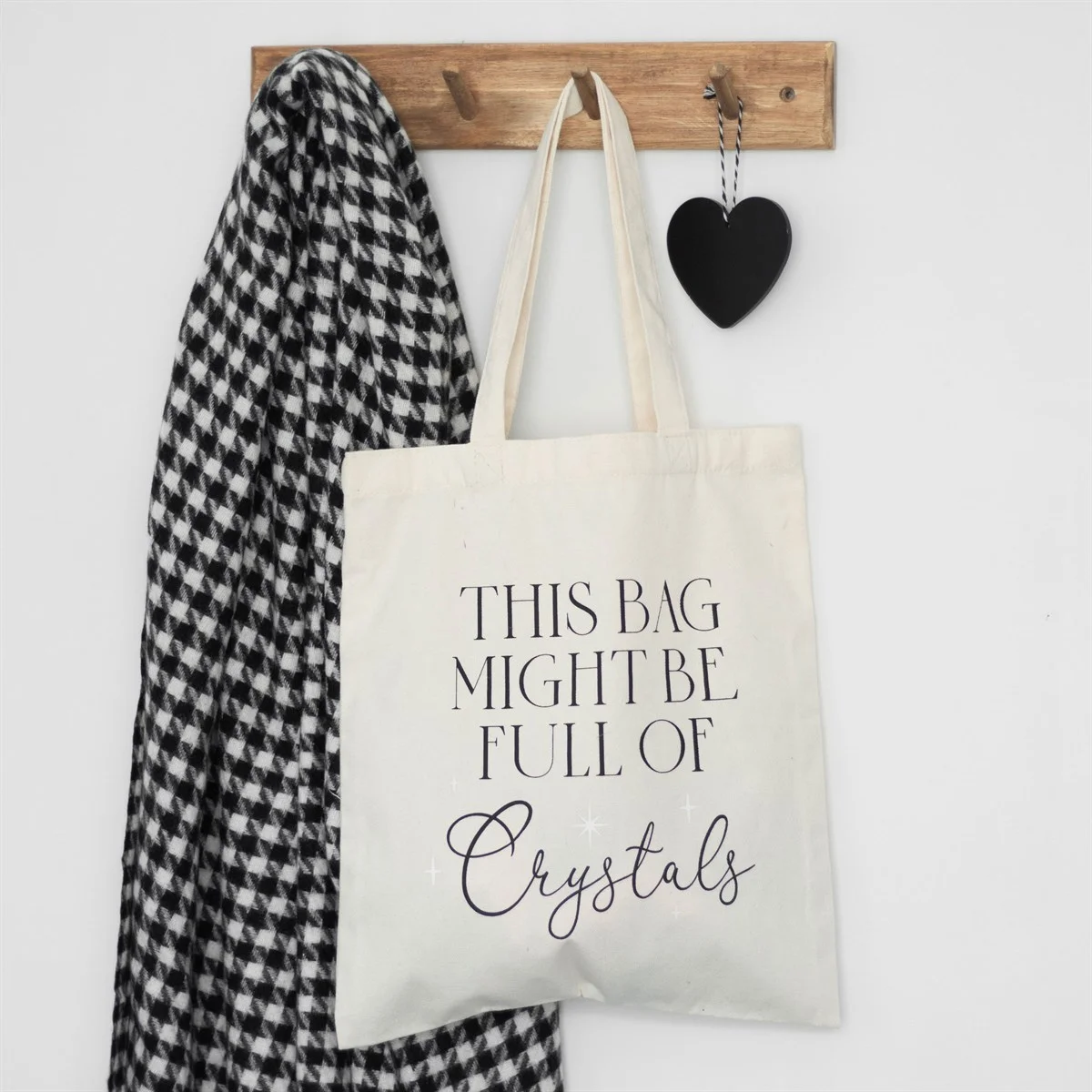 White cotton tote bag with black text "This bag might be full of crystals" on a plain background