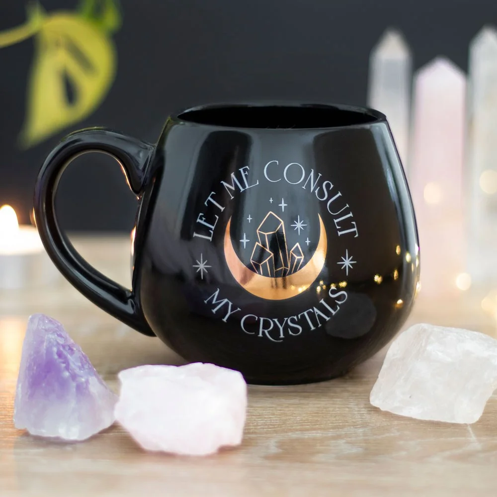 Black crystal themed mug with gold foil crescent moon and crystals, text "Let me consult my crystals," 500ml capacity