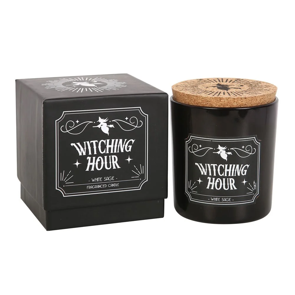 Lit white sage candle in a glass jar with Witching Hour label, emitting a soft warm glow