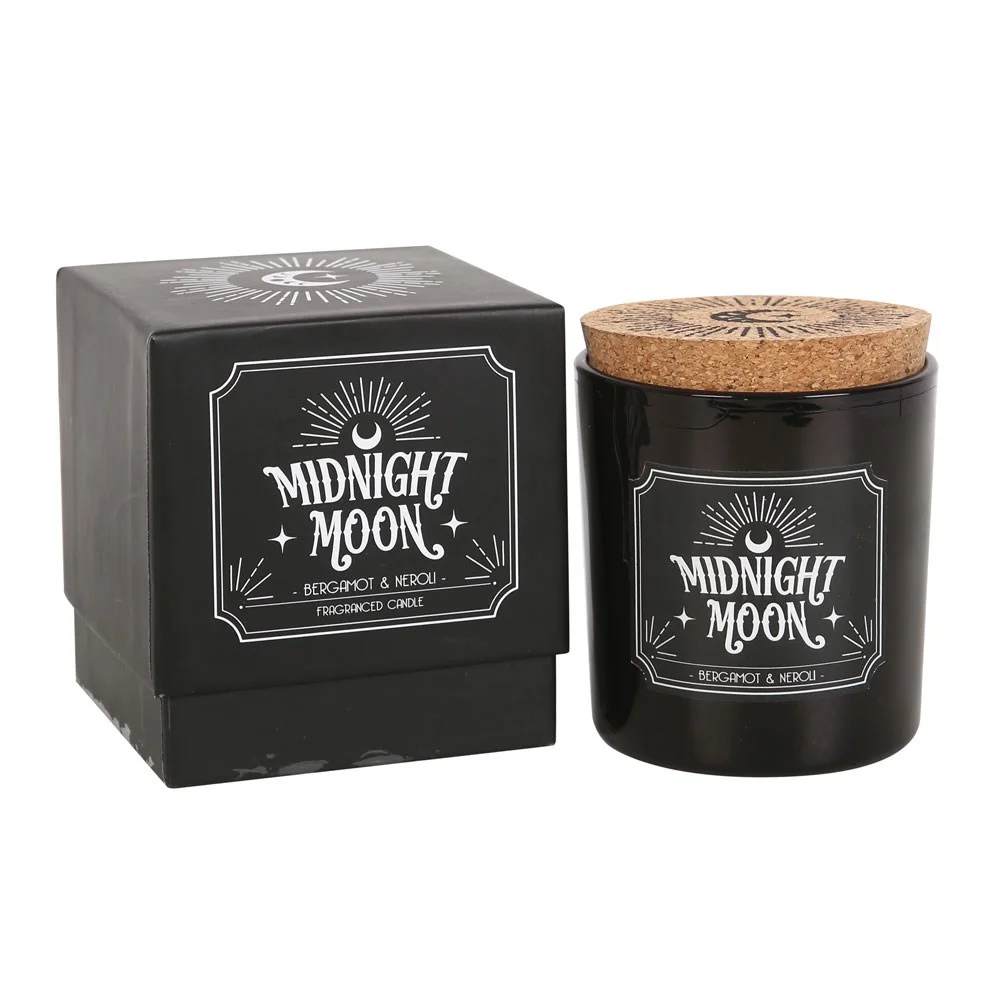 Midnight Moon bergamot scented candle in a frosted glass jar with warm glowing flame on a dark background