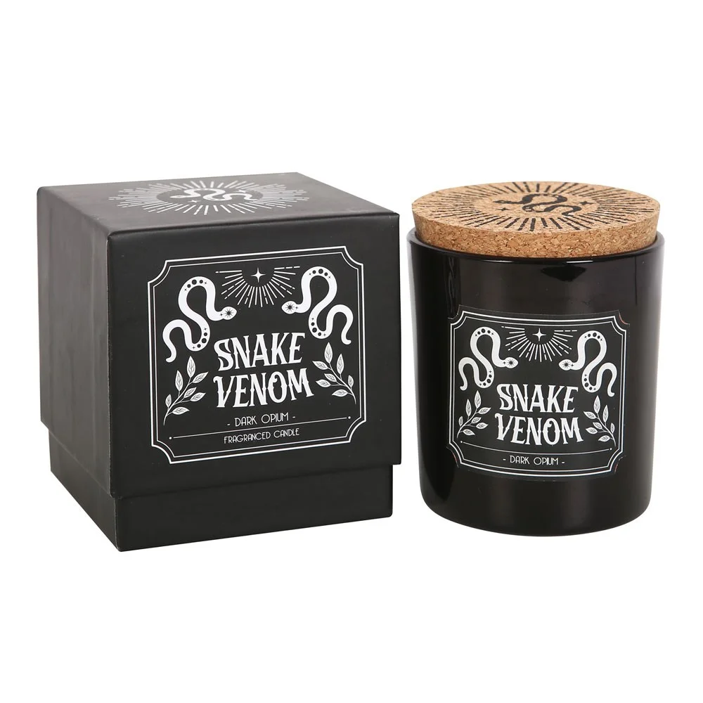 Lit Snake Venom dark opium candle in a glass jar with black label, emitting warm glow and smoky ambiance
