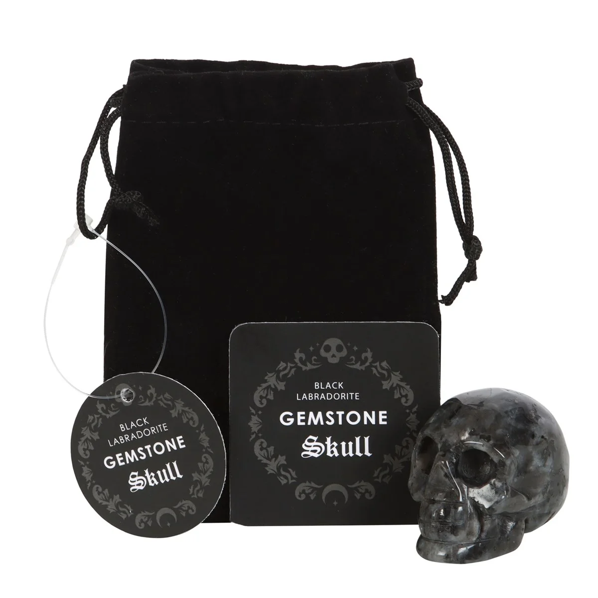 Black labradorite skull crystal resting on white surface with black drawstring pouch beside it for storage and protection