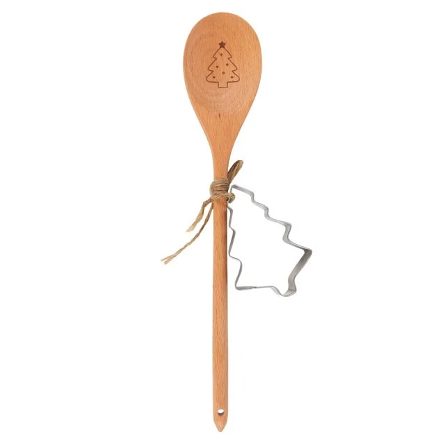 Beech wood spoon and tree-shaped cookie cutter in Christmas baking set on white background