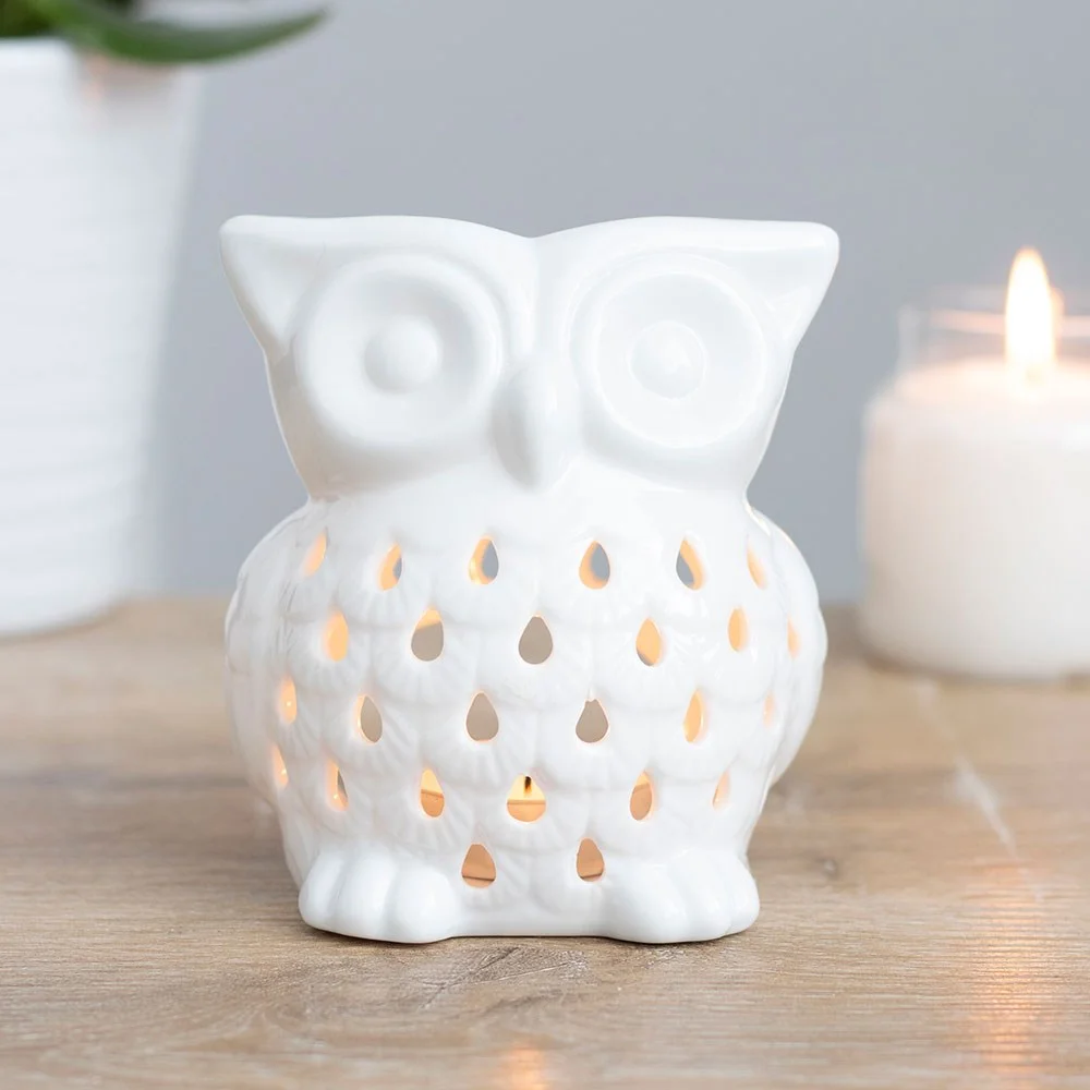 Charming white owl oil burner with deep bowl holding a lit tealight.