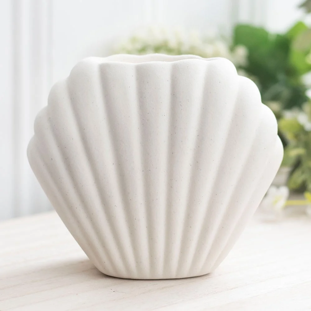 Contemporary neutral stone seashell oil burner with a hollow center for fragrance oils or wax melts on white background