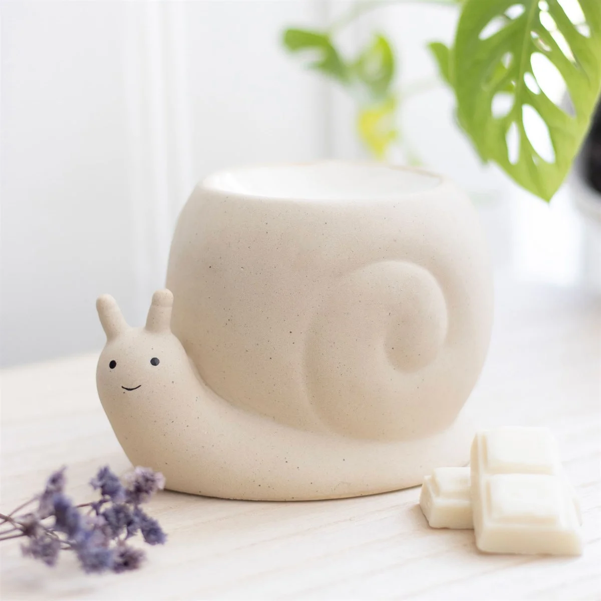 Neutral stone-coloured snail oil burner shaped like a playful snail, designed for fragrance oils or wax melts