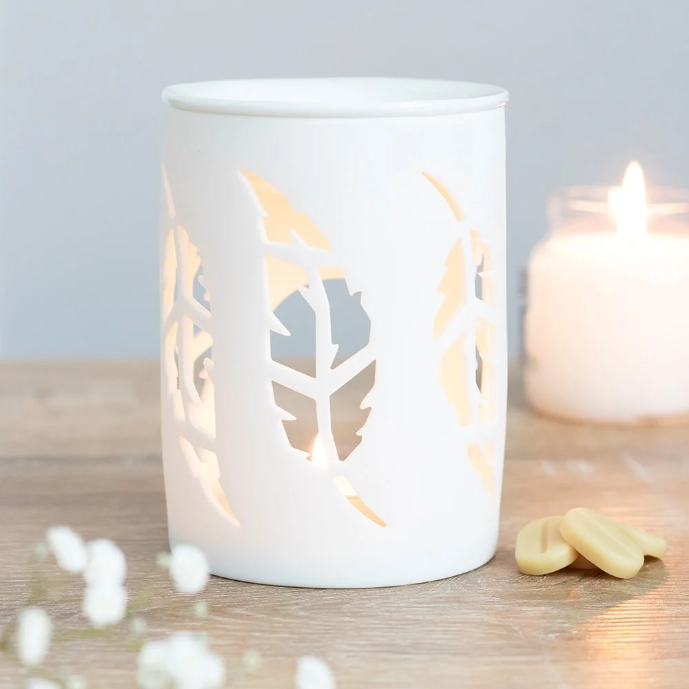 White ceramic oil burner with feather cutouts and built-in dish for fragrance oil or wax melts on a tealight base