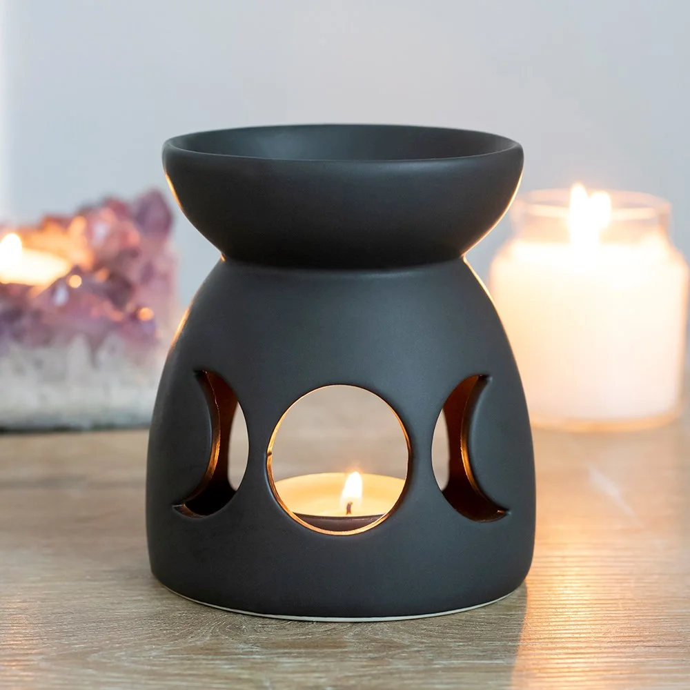 Black ceramic oil burner with triple moon cutout design and matt finish, 10cm tall, ideal for fragrance oils or wax