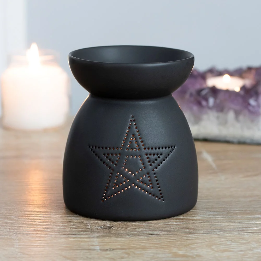 Black ceramic oil burner with pentagram cutout design and matt finish, 10cm tall, ideal for fragrance oils and wax.