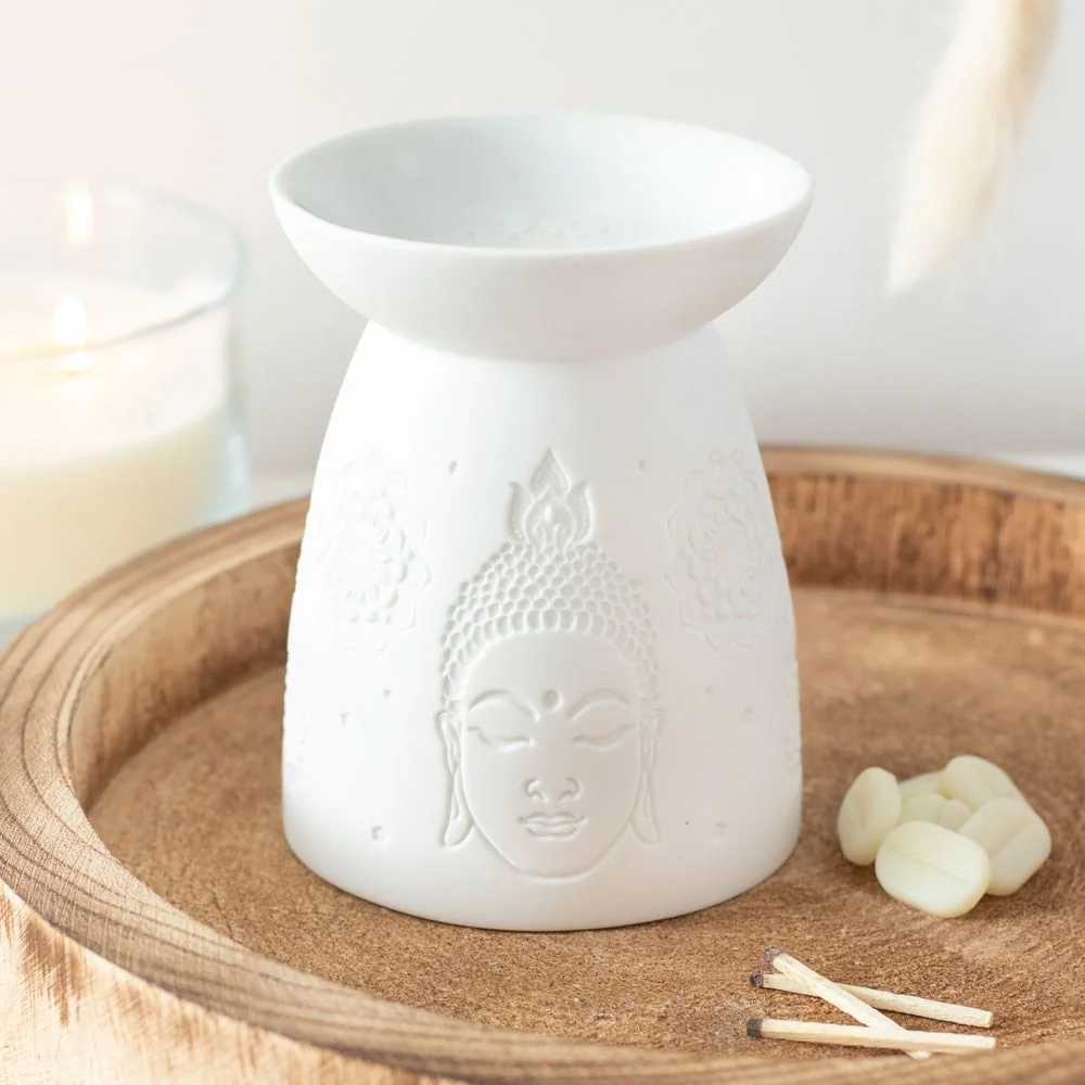 Matte white ceramic oil burner shaped like a Buddha face with a hollow center for tealight candle and wax melts