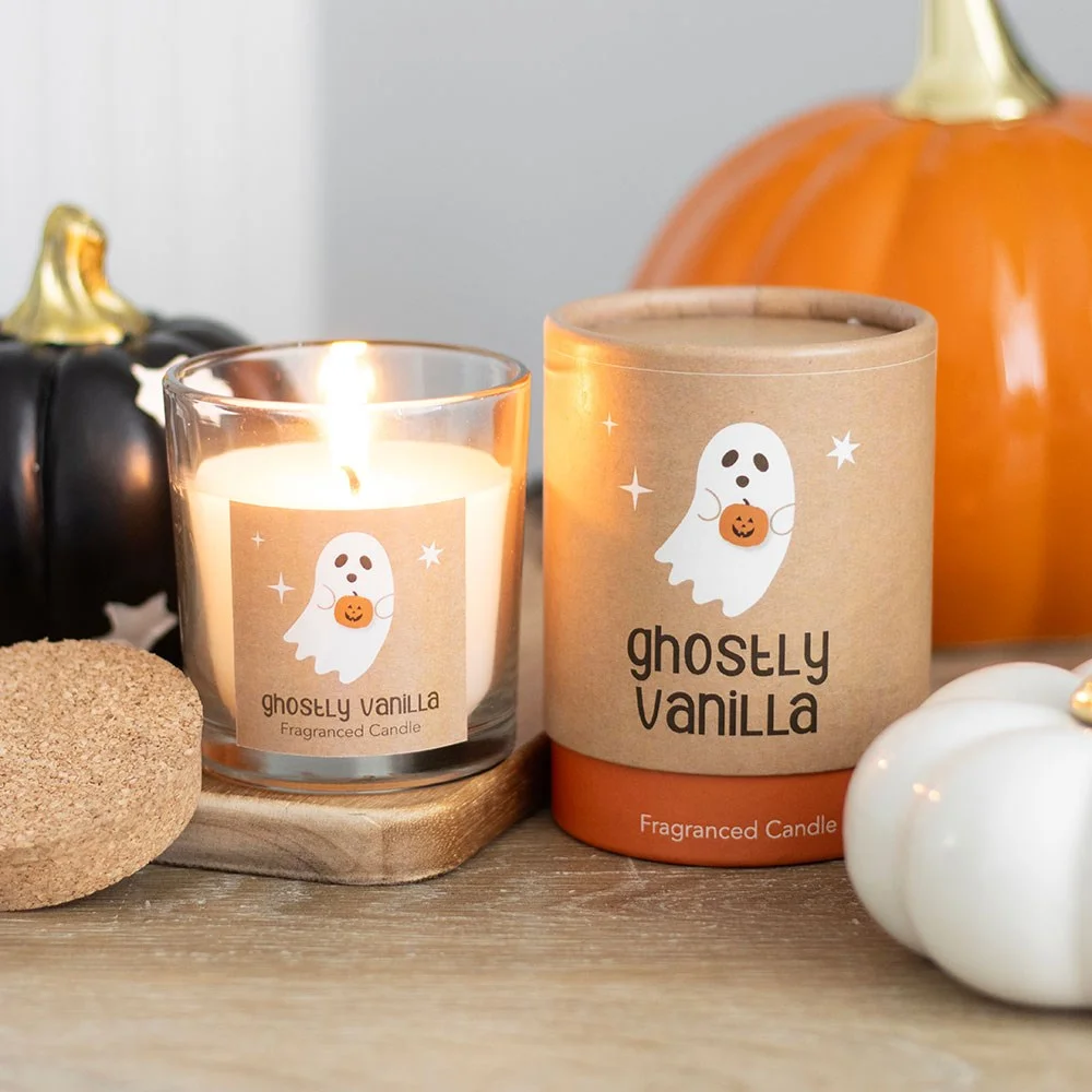 White Ghostly Vanilla scented candle in glass jar with Halloween-themed label and lit wick on white background