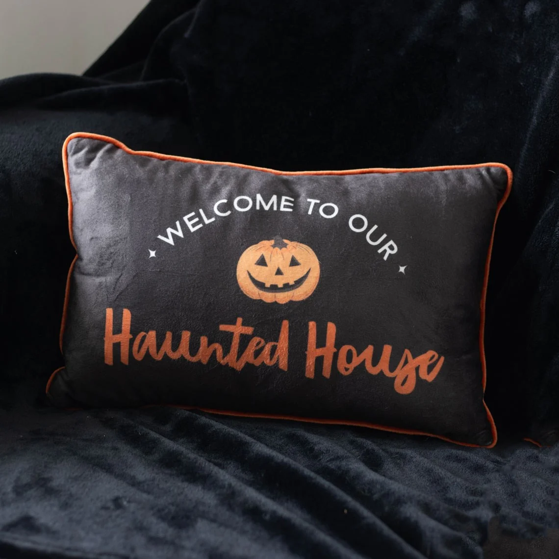 Rectangular 40cm haunted house cushion with a jack-o'-lantern and 'Welcome to our haunted house' text design