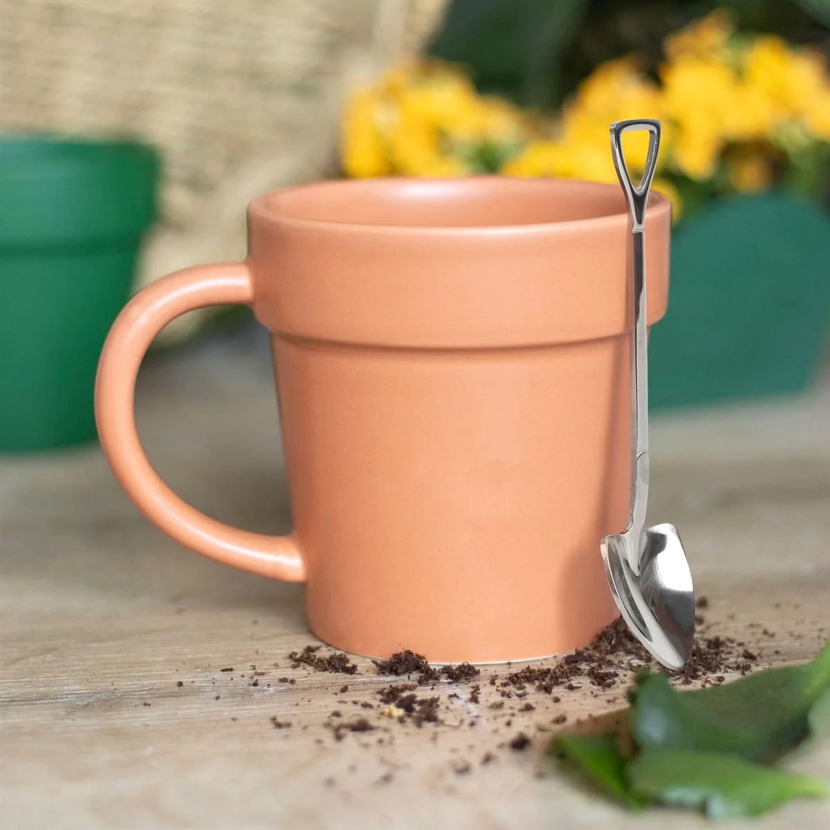 Plain ceramic plant pot mug with a matching mini shovel spoon on a white background