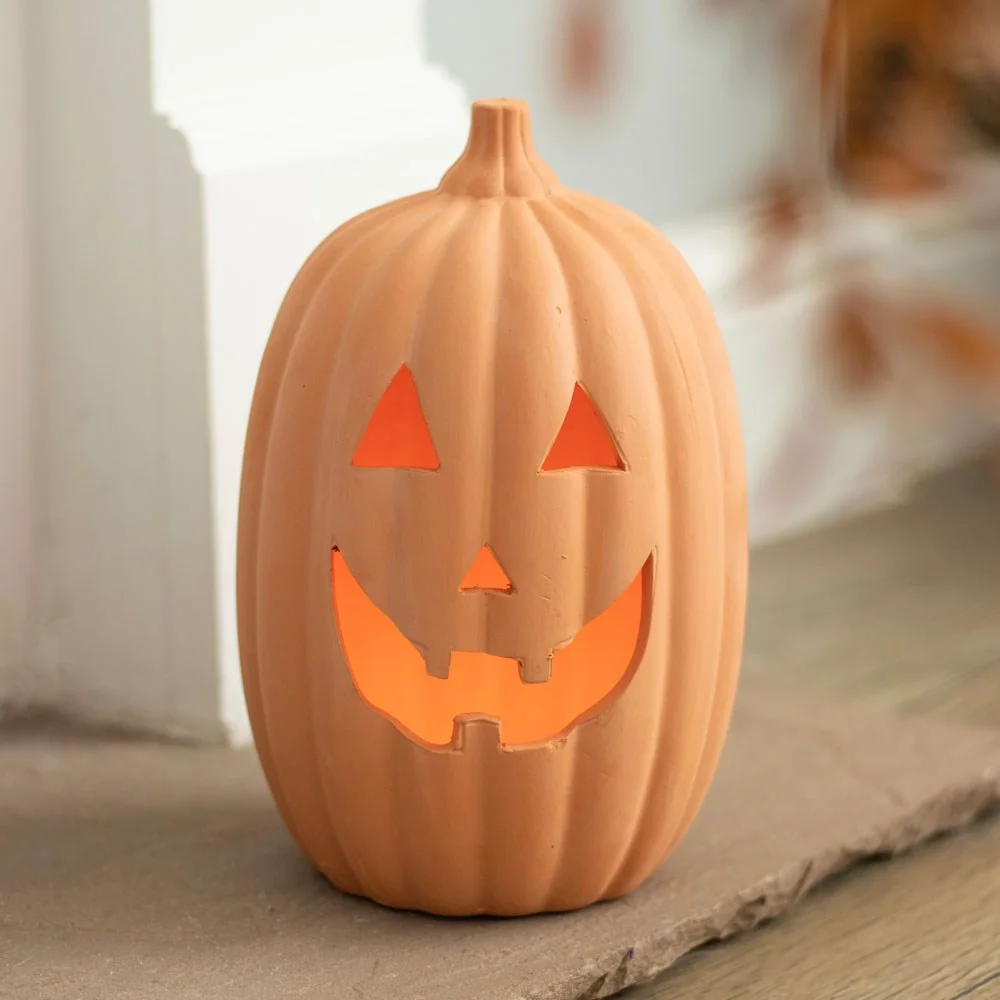 23cm terracotta pumpkin ornament with carved jack-o-lantern face and tealight candle holder inside