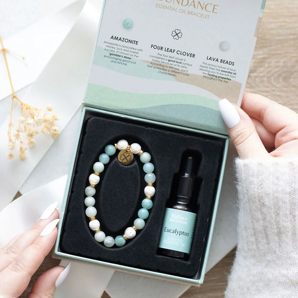 Amazonite crystal bracelet with lava beads and four-leaf clover charm in luxury gift box with eucalyptus oil bottle
