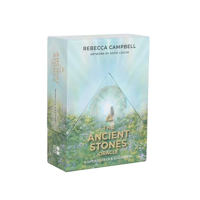 The Ancient Stones Oracle Cards deck fanned out showing colorful stone designs and a guidebook on a wooden surface