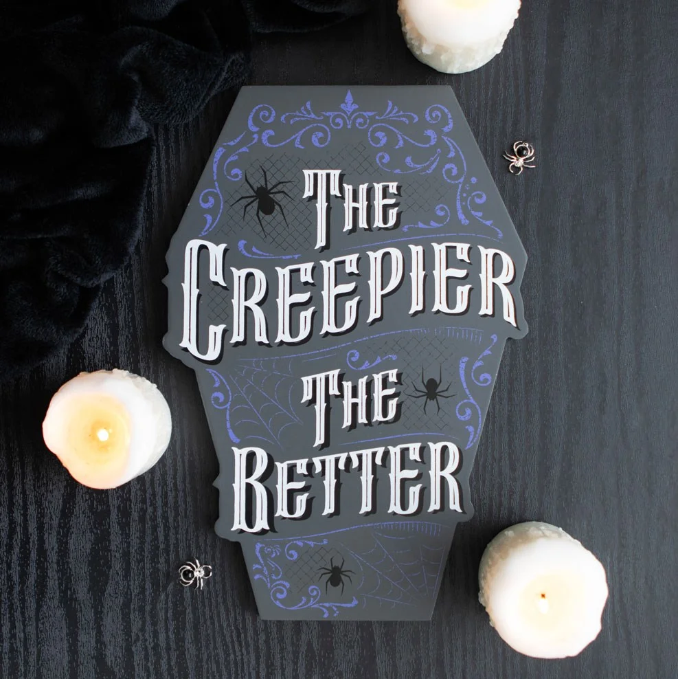 Muted grey coffin shaped sign with "The Creepier the Better" text, evoking a foggy graveyard atmosphere