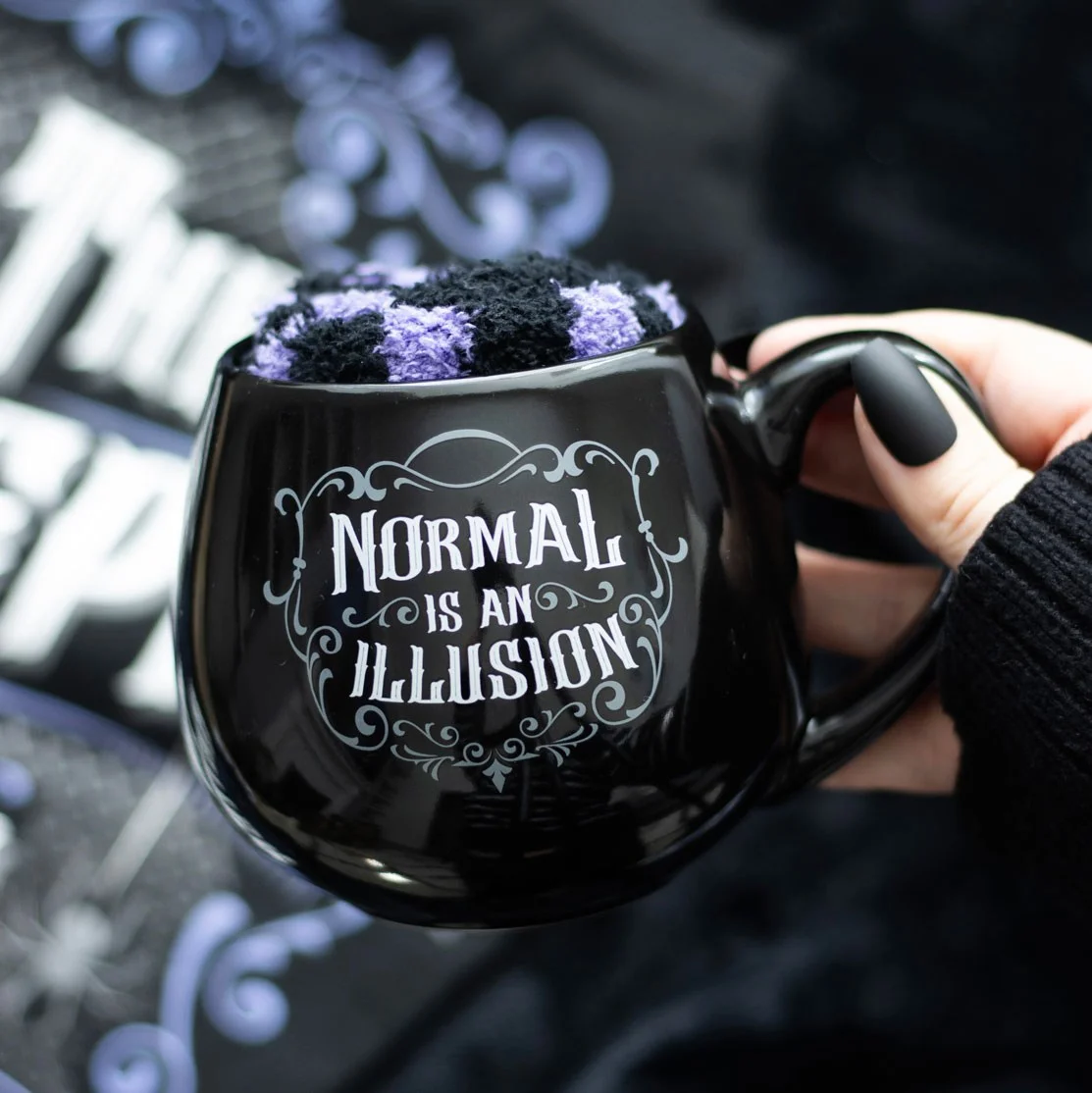 Black gothic mug gift set with "Normal is an Illusion" text and matching black and purple striped socks on white background