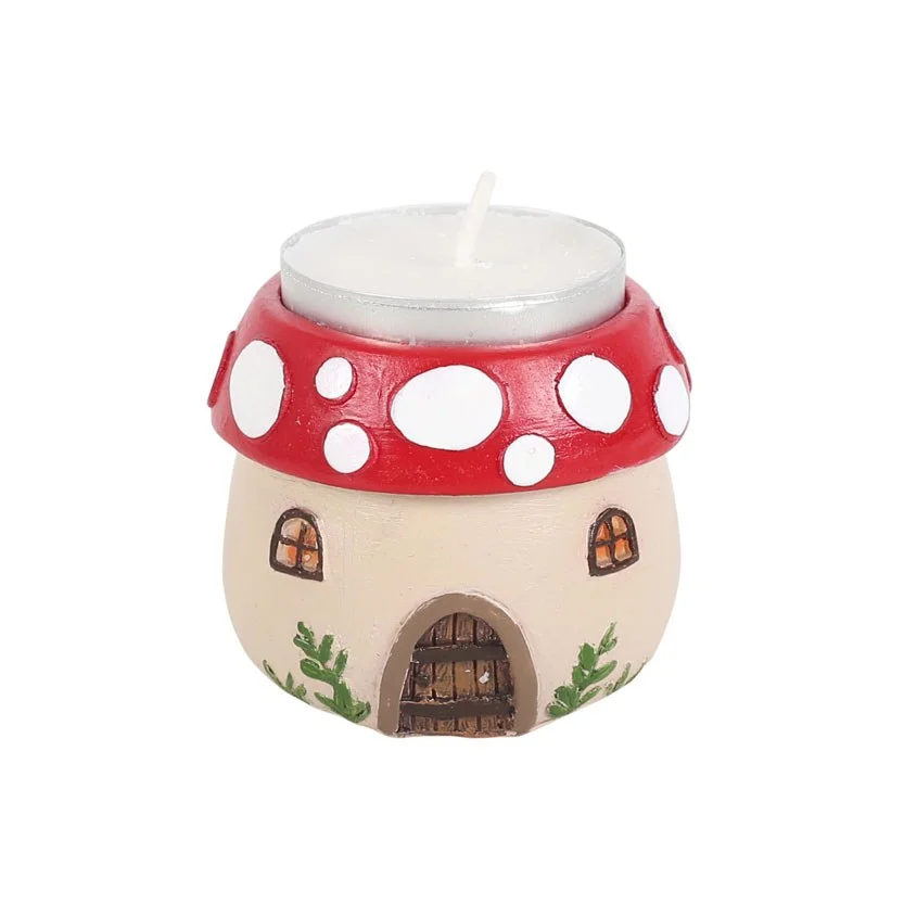 Whimsical mushroom house tealight holder made of resin, detailed with a winter forest theme and a lit tealight inside