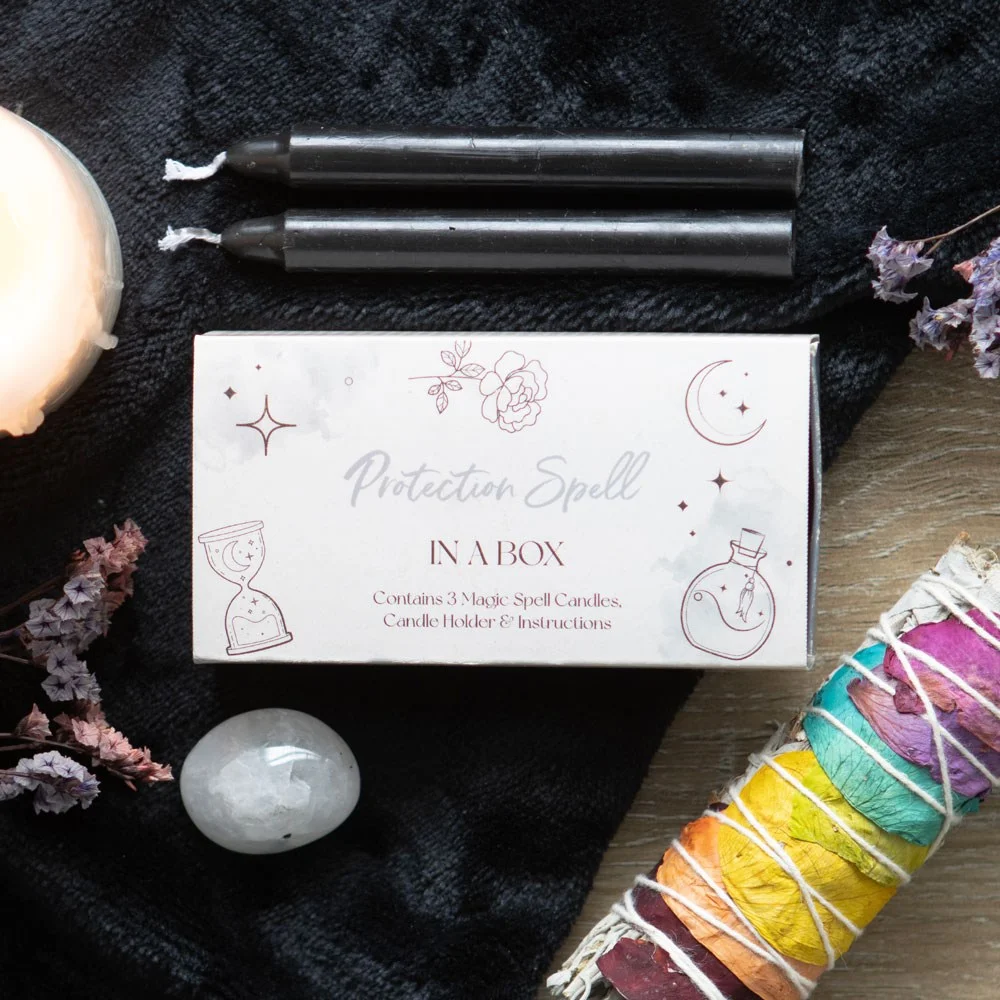 Mini protection spell kit with grey candles in sliding box doubling as candle holder and instruction sheet visible