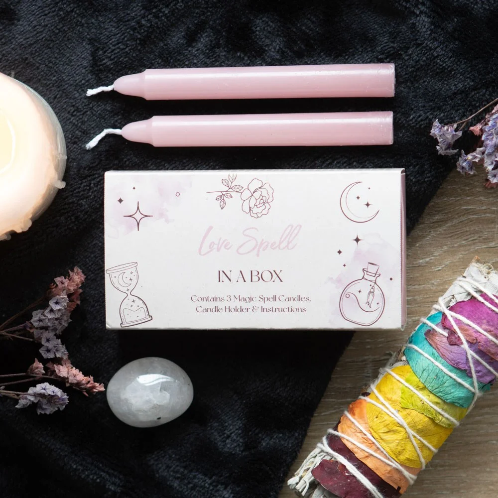 Mini love spell kit in a sliding box with three pink unscented candles and instructions for manifesting love and romance