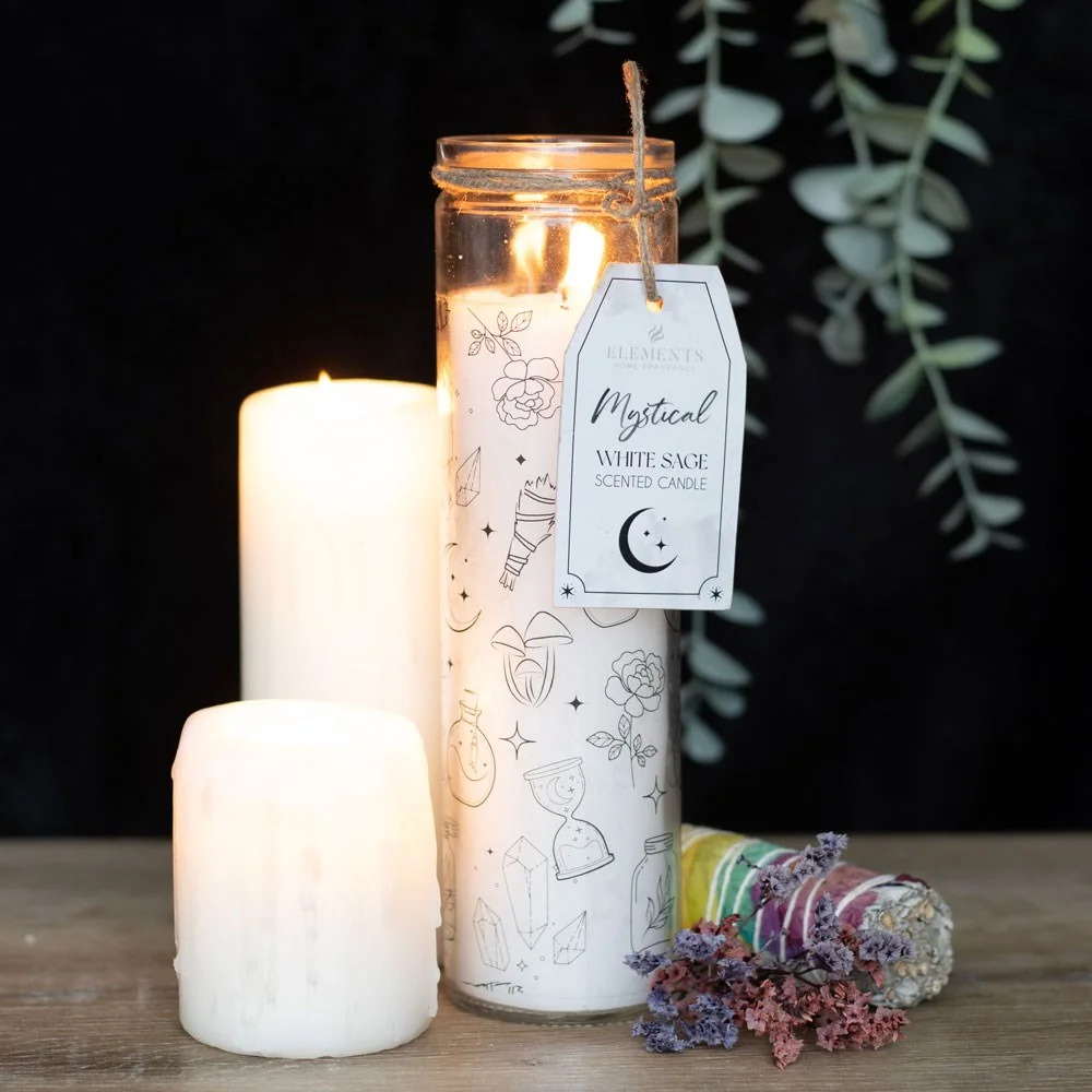Tall white tube candle labeled Mystical White Sage Candle with soft glowing flame on a dark background