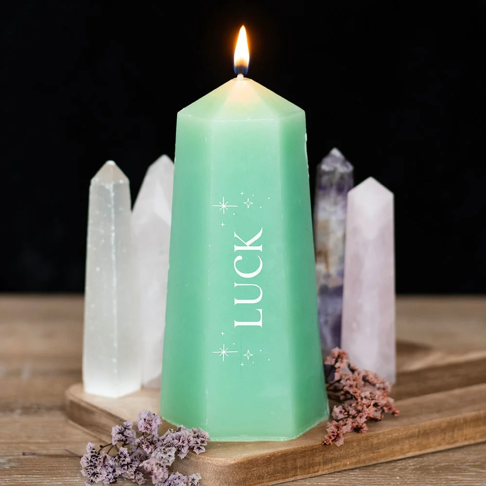 Luck crystal candle shaped like a green crystal tower with rough aventurine crystal inside on white background
