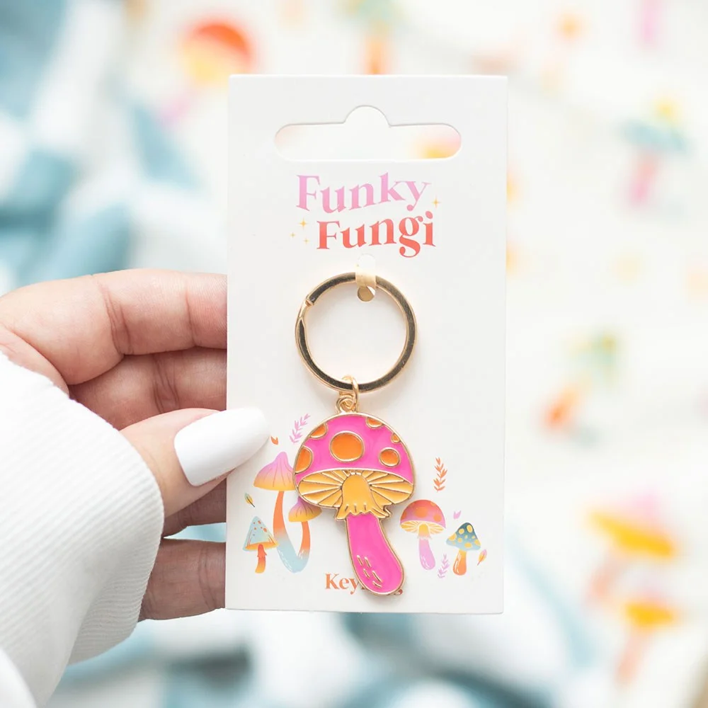 Brightly coloured enamel funky mushroom keyring with red cap and white spots on a silver keyring loop