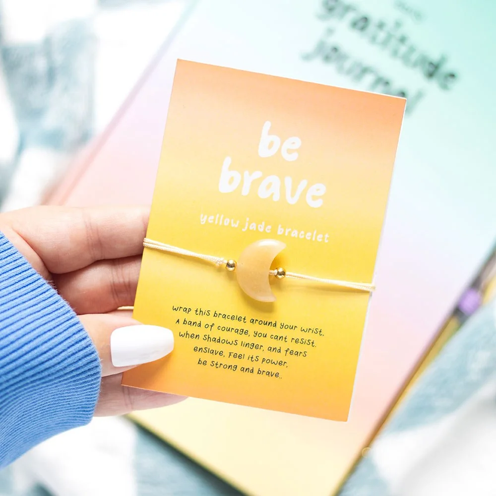 Yellow jade bracelet with moon-shaped crystal beads on a 'Be brave' backing card with an encouraging poem