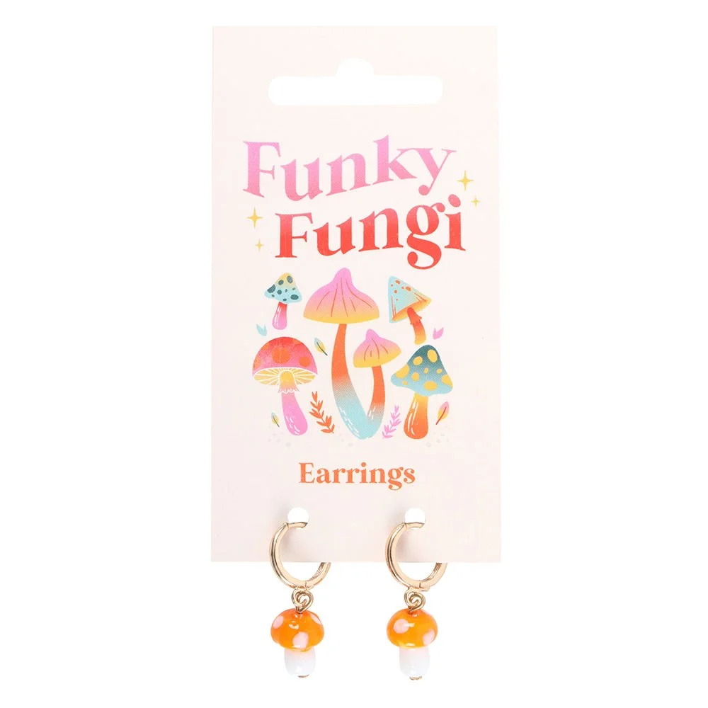 Pair of orange mushroom earrings with glass toadstool charms hanging from small gold hoops on white background
