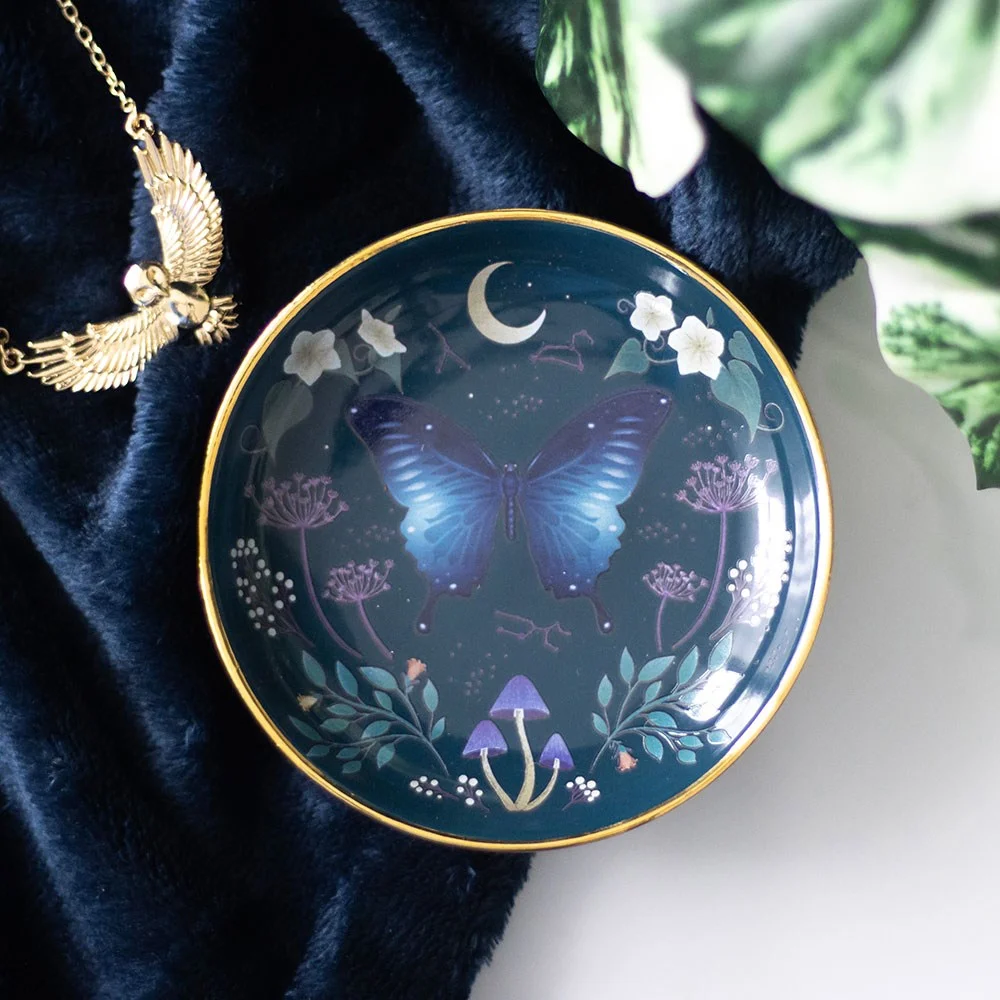Round Midnight moth trinket dish with blue moth design, floral details, and metallic gold edging on white ceramic dish