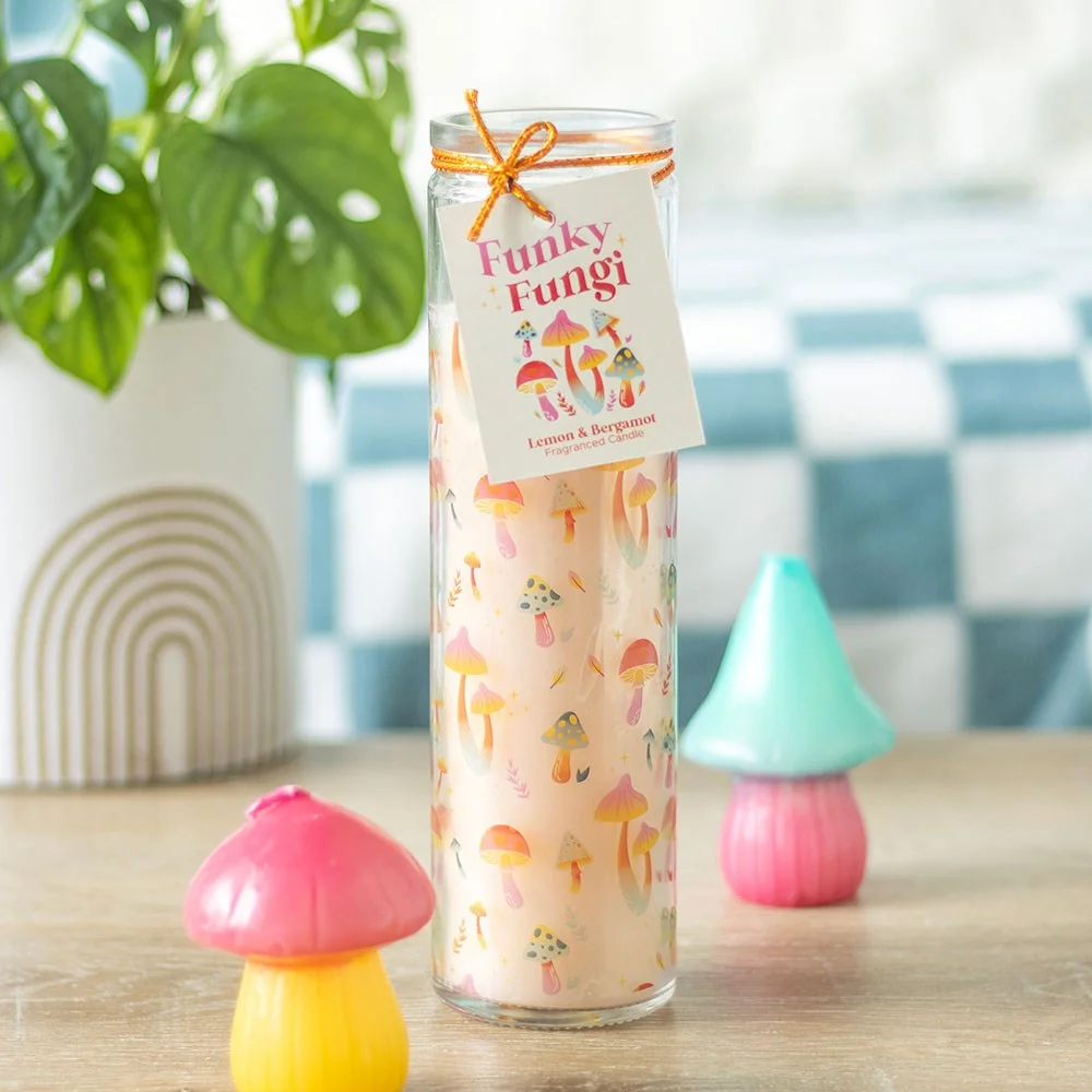 Tube candle with colourful mushroom print design, lemon and bergamot scent, in a clear glass jar on white background