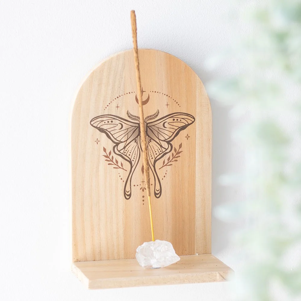 Natural wooden incense holder shelf with intricate luna moth design hanging on a wall, holding incense sticks