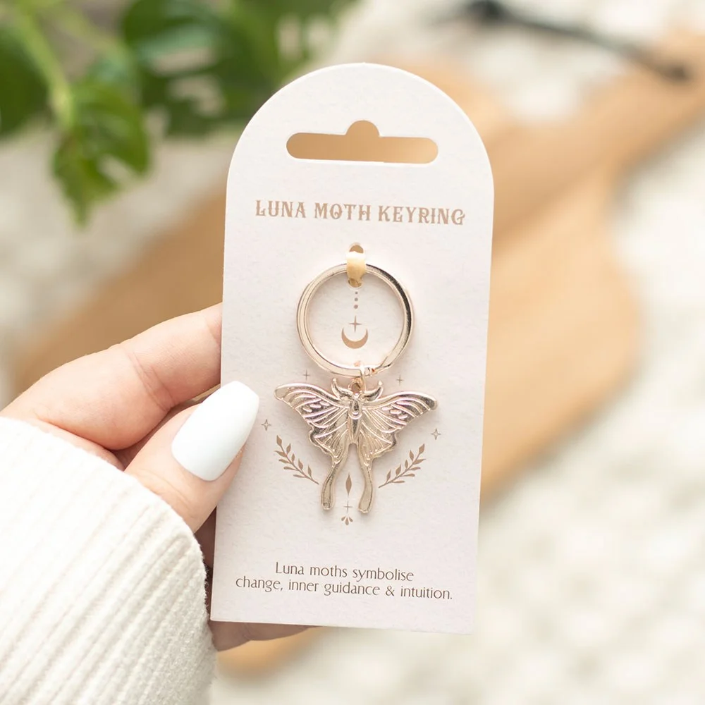Silver luna moth keyring on a matching backing card, showing detailed moth design and metal keyring loop