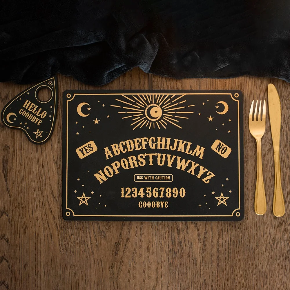 Black and gold celestial talking board placemat set with coaster on wooden table, styled for dinner party