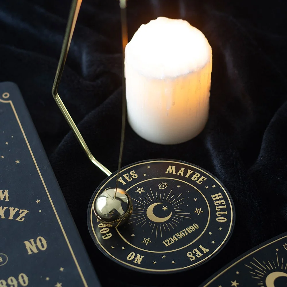 Metal talking board decision maker with gold-tone spherical pendulum on a wooden desktop background