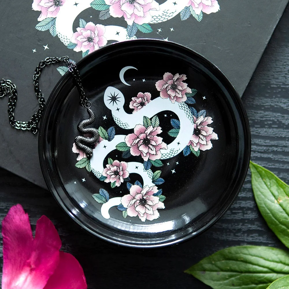 Floral snake trinket dish with white snake curled among pink flowers on black starry background for jewellery storage
