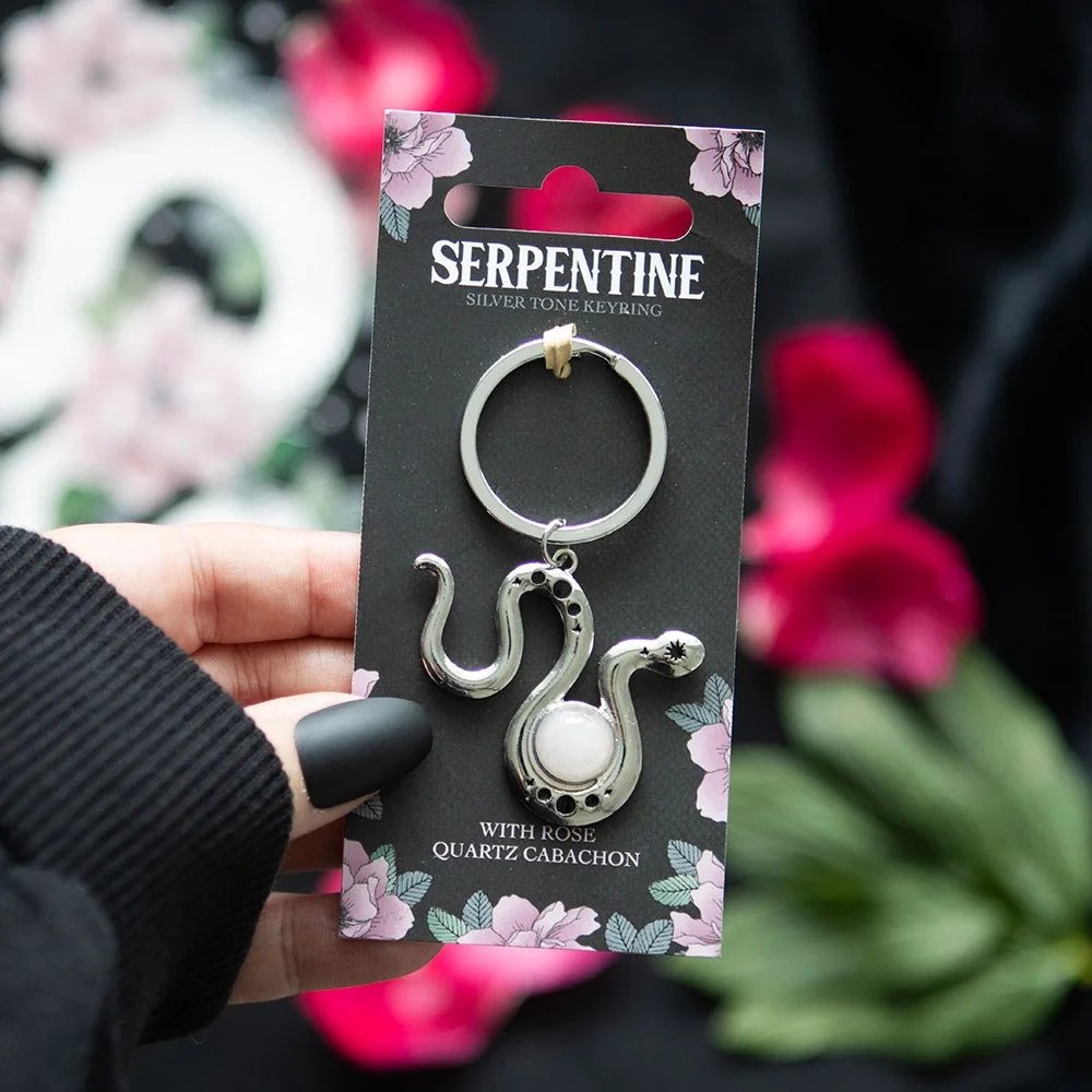 Silver-toned snake keyring rose quartz crystal curled around pink cabochon on floral backing card for gifting