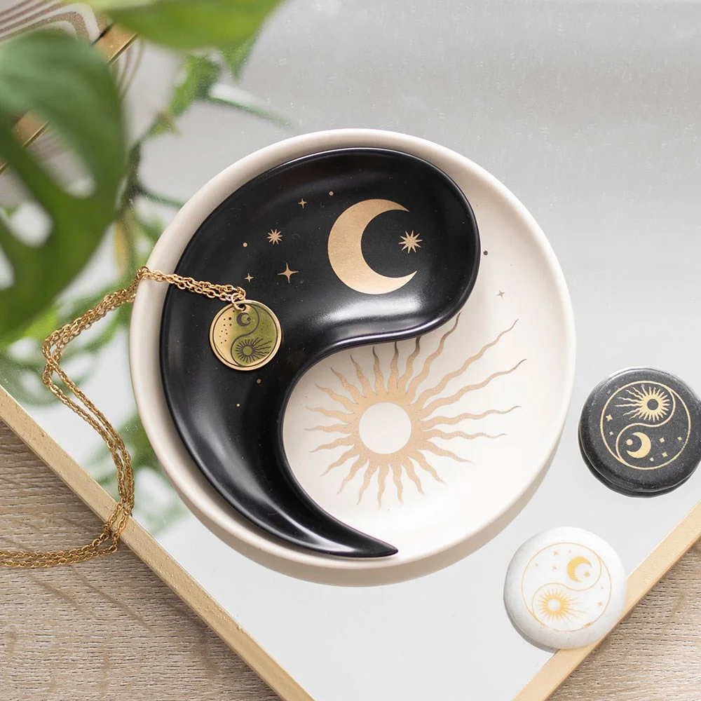 Two-piece stacking ying yang trinket dish with sun and crescent moon design on white background