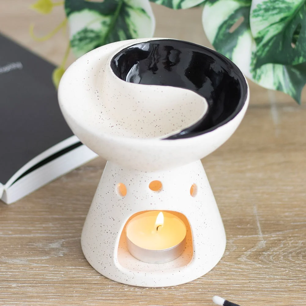 Ceramic yin yang oil burner and wax warmer with dual compartments for essential oils and wax melts on a wooden surface