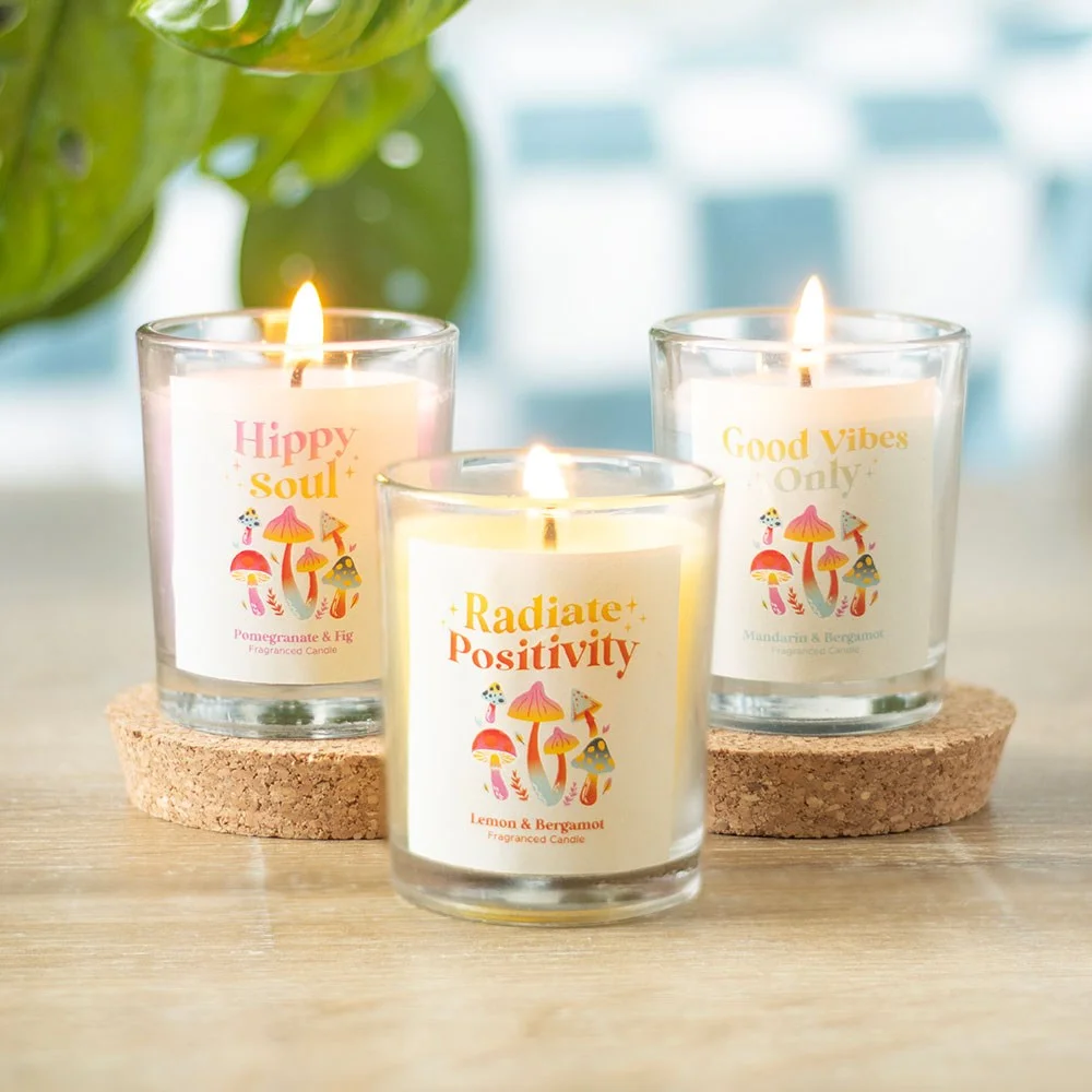 Set of 3 colorful glass mushroom votive candles with unique scents on a white background