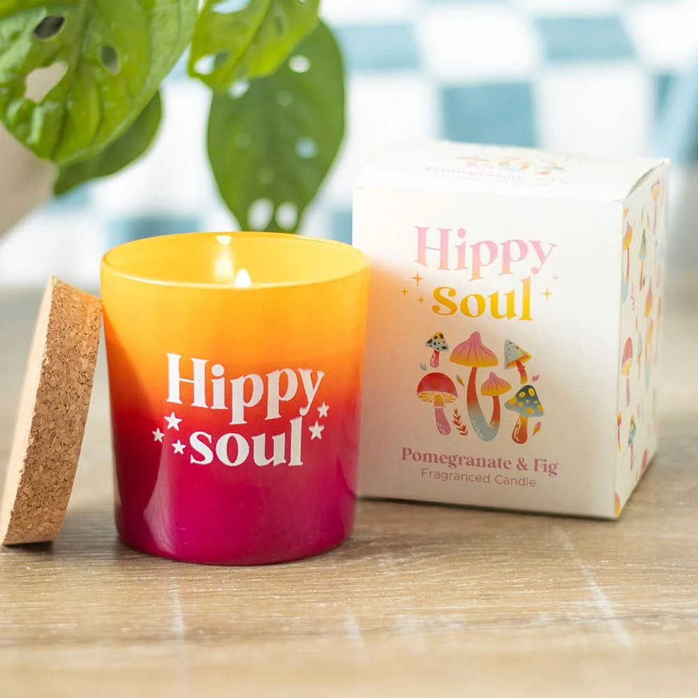 Pomegranate fig candle in vibrant orange and red glass pot with cork lid on white background