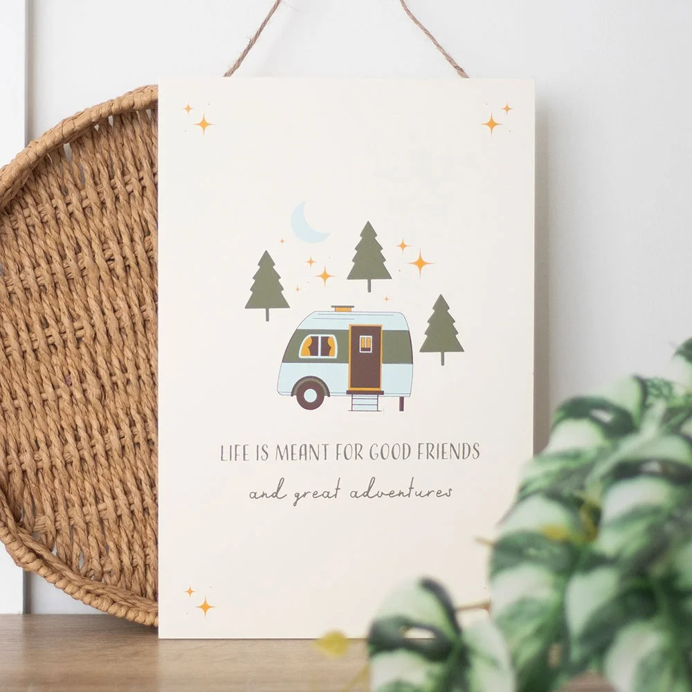 Outdoor hanging sign with caravan scene and text "Life is meant for good friends and great adventures