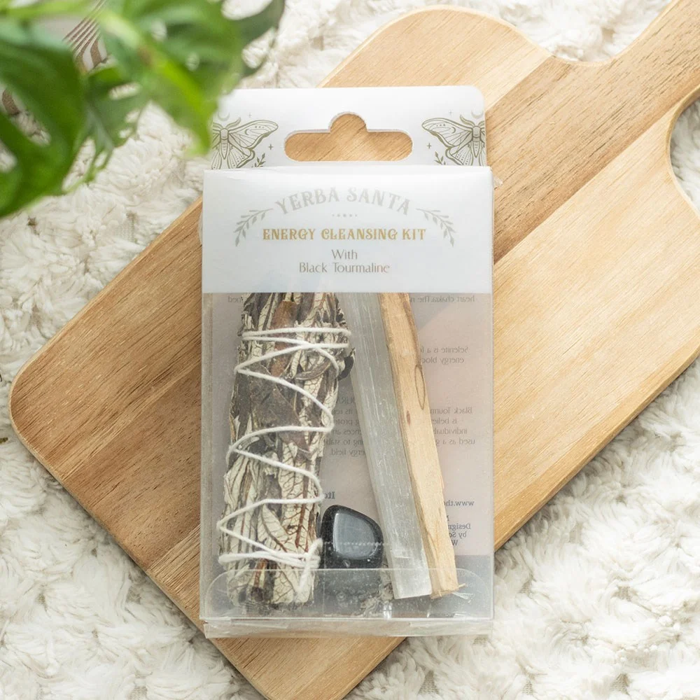 Yerba Santa sage bundle, palo santo stick, selenite wand, and black tourmaline crystal in energy cleansing smudge kit display
