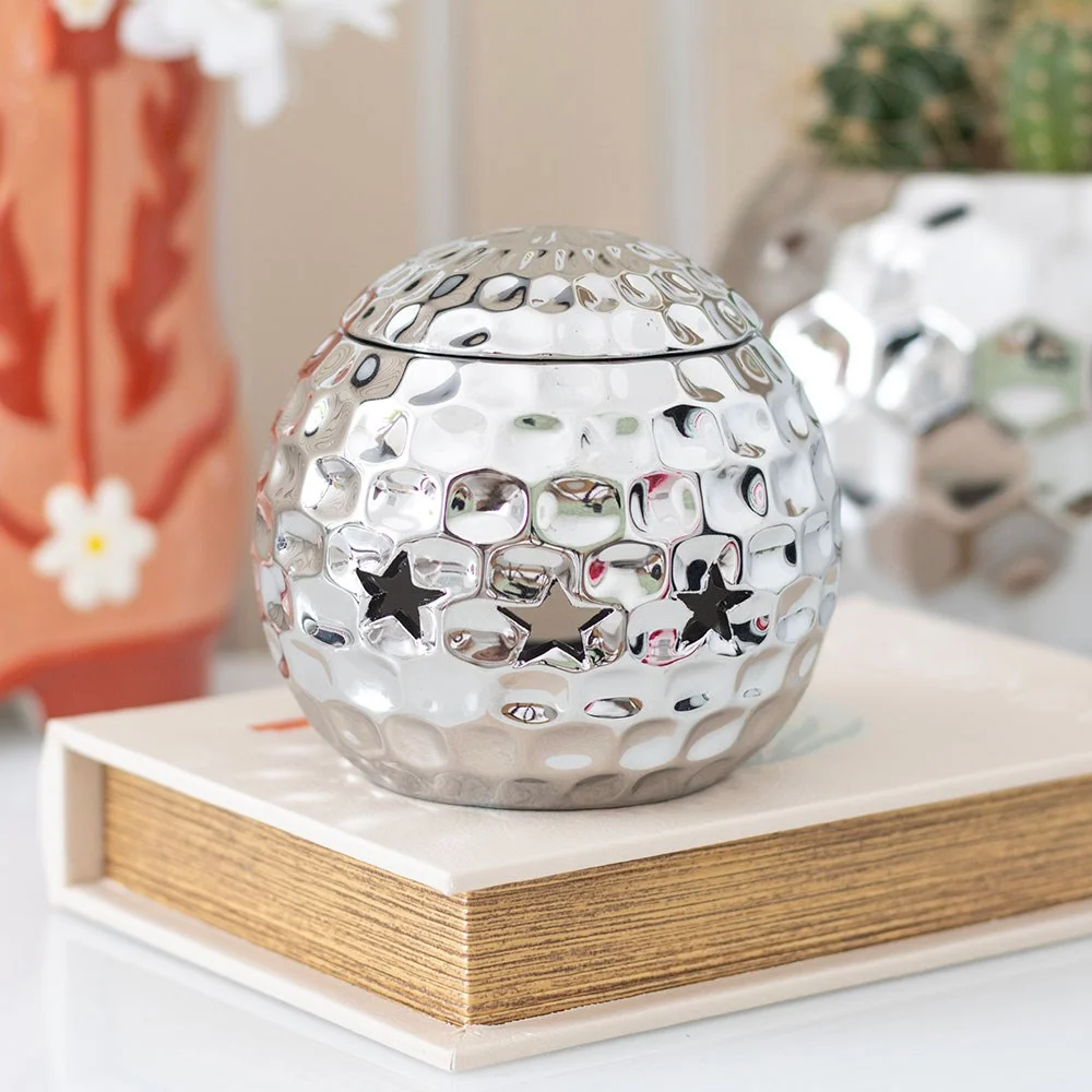Silver disco ball shaped oil burner with reflective facets, designed for fragrance oil use in home decor