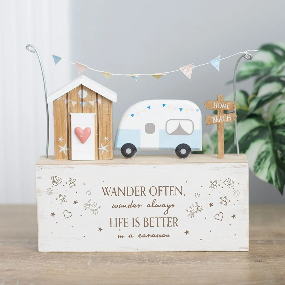 Wooden caravan ornament featuring a caravan, beach hut, bunting, and the quote about wandering and caravans