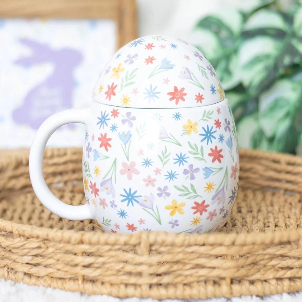 Egg-shaped ceramic spring floral mug with pastel flower design and lid for keeping drinks warm on white background