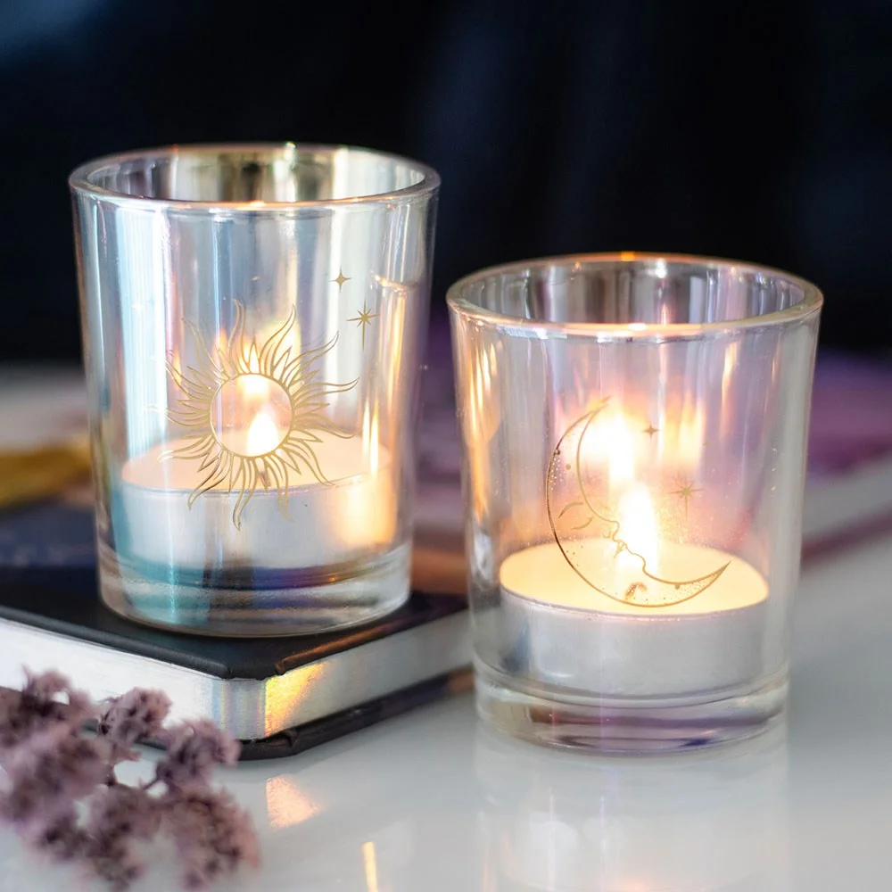 Set of 2 iridescent candle holders with sun and moon designs, gold foil details, and colour-shifting glass finish