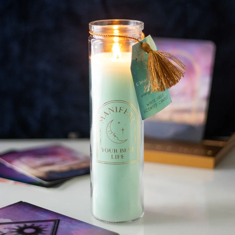 White sage candle in a clear tube with gold 'Manifest your best life' text and clear quartz crystals inside