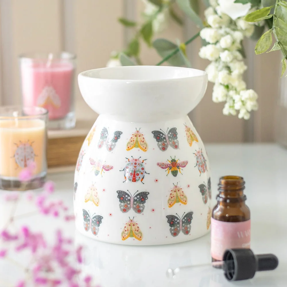 Floral oil burner with colourful bug and flower design on white ceramic wax warmer for home fragrance